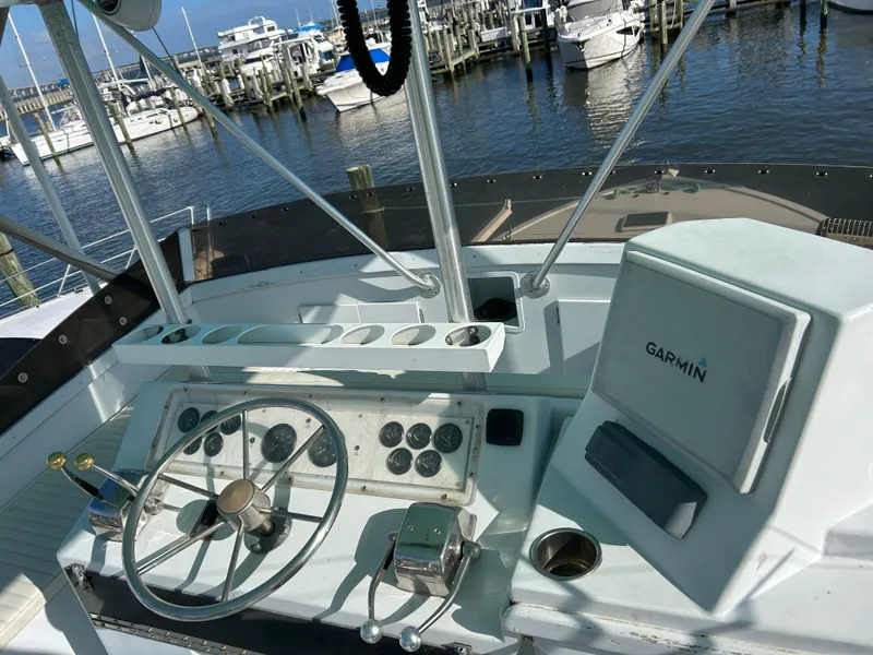 Slide: The Image of Boat helm with Garmin navigation, steering wheel, and controls, docked at marina. - 9