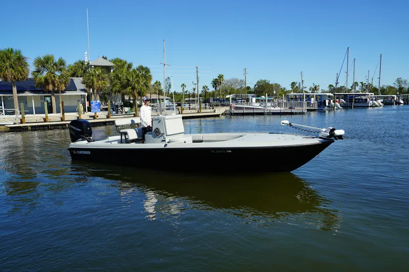 Slide: The Image of 2016 Contender 25 Bay boat docked in a marina with palm trees and clear sky. - 2