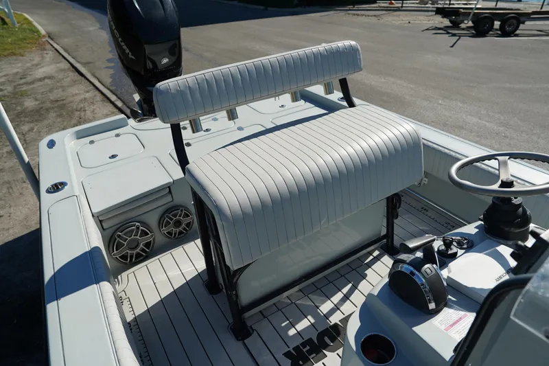 Slide: The Image of 2016 Contender 25 Bay boat interior with striped seating and steering console. - 26