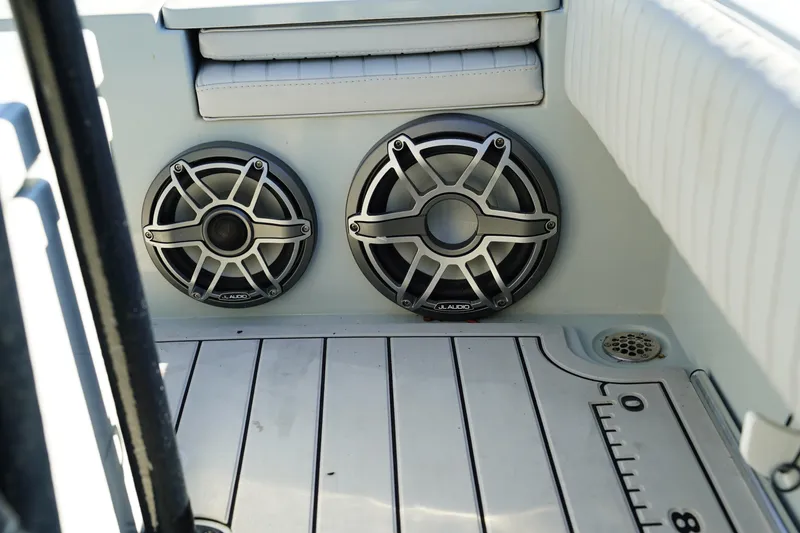 Slide: The Image of Contender 25 Bay 2016 boat interior with dual speakers and cushioned seating. - 36