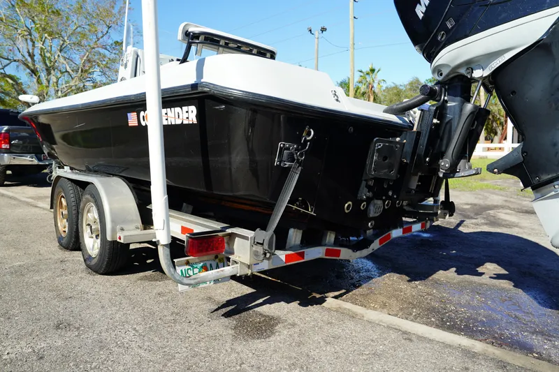 Slide: The Image of 2016 Contender 25 Bay boat on trailer, black hull, parked outdoors. - 38