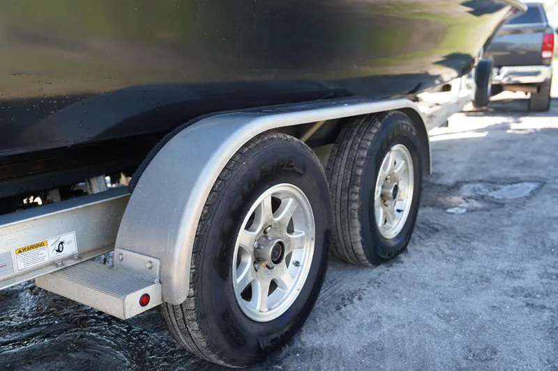 Slide: The Image of 2016 Contender 25 Bay boat trailer with dual wheels on a concrete surface. - 42