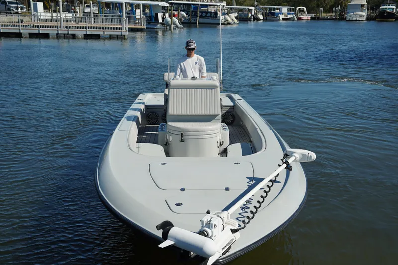 Slide: The Image of 2016 Contender 25 Bay boat on calm water, docked with a person at the helm. - 7