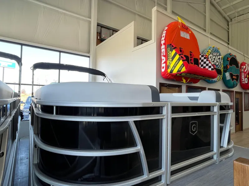 The Image of 2025 Godfrey Sweetwater 2086 C pontoon boat displayed indoors with colorful inflatables. - 0