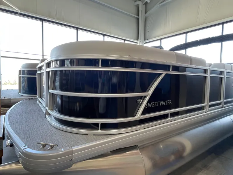 Slide: The Image of 2025 Godfrey Sweetwater 2086 C pontoon boat in showroom, featuring sleek design and modern build. - 2