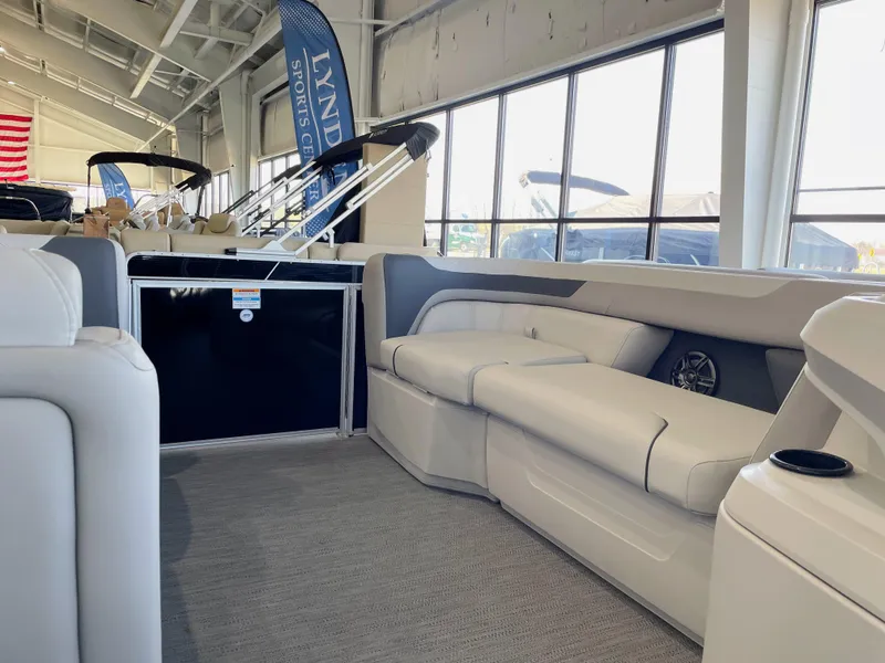 Slide: The Image of 2025 Godfrey Sweetwater 2086 C pontoon boat interior with plush seating in showroom. - 6