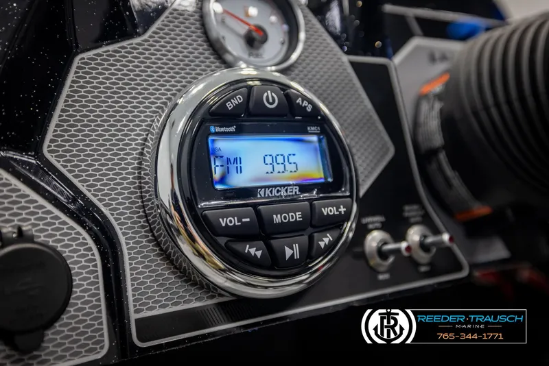 Slide: The Image of 2025 Lund 1875 Pro V Bass XS dashboard with Kicker audio system displaying FM 99.5. - 20