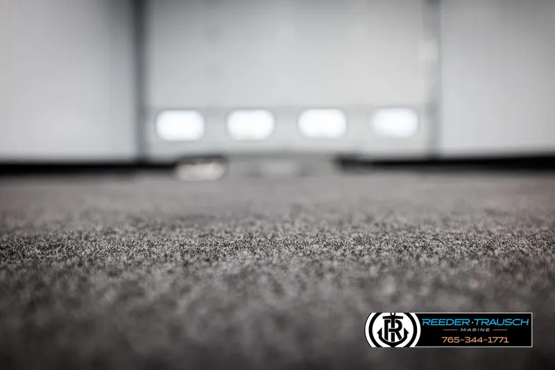 Slide: The Image of Carpeted interior of 2025 Lund 1875 Pro V Bass XS boat, blurred background. - 36