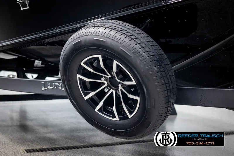 Slide: The Image of 2025 Lund 1875 Pro V Bass XS trailer wheel, black alloy rim, Reeder-Trausch Marine logo. - 44