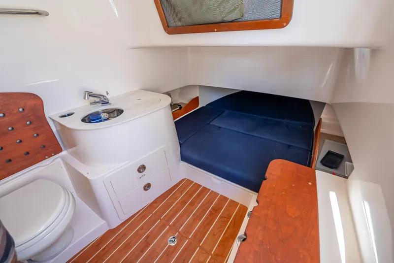Slide: The Image of 2023 Grady-White 336 Canyon cabin interior with bed, sink, and wooden accents. - 22