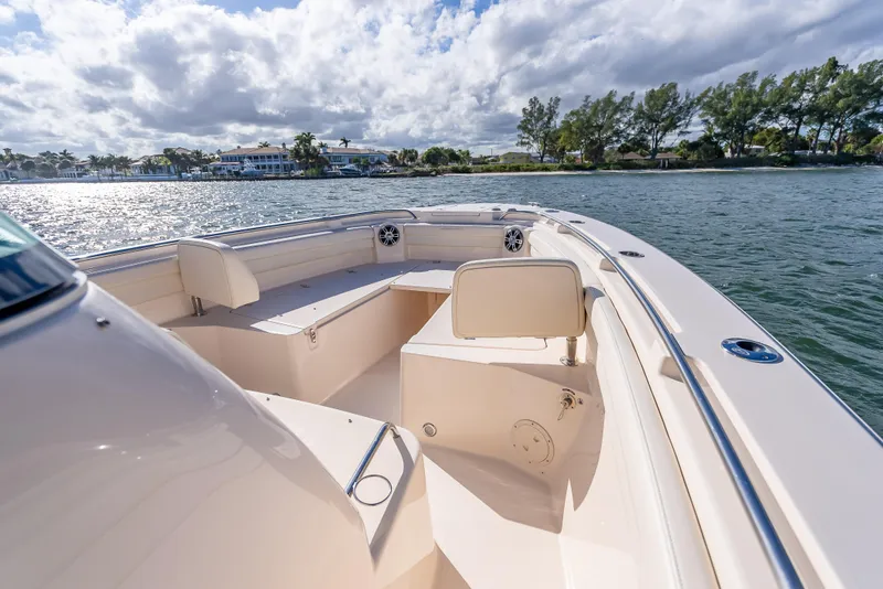 Slide: The Image of 2023 Grady-White 336 Canyon boat on scenic waterway under cloudy sky. - 24