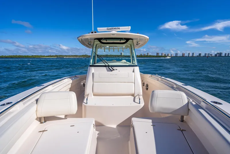 Slide: The Image of 2023 Grady-White 336 Canyon boat on open water, clear sky, city skyline in background. - 27