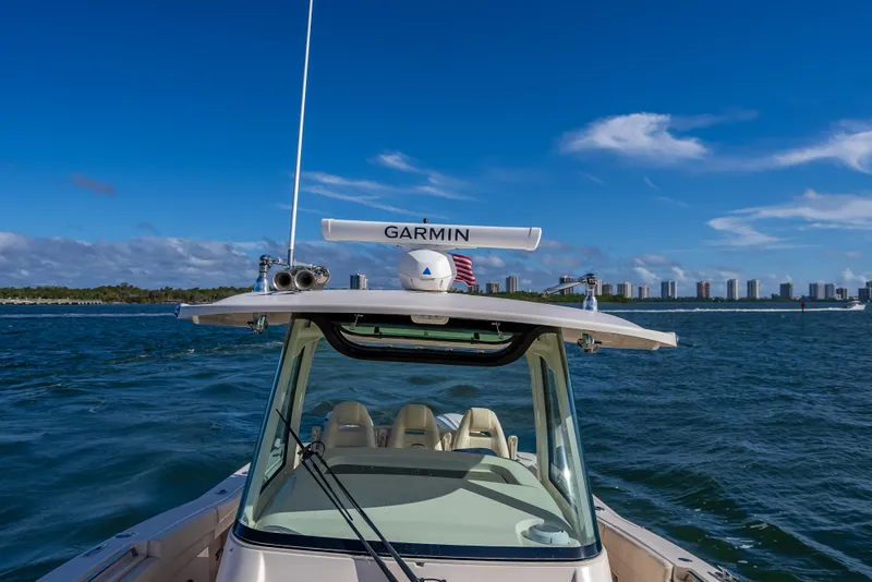Slide: The Image of 2023 Grady-White 336 Canyon boat on open water with city skyline. - 29