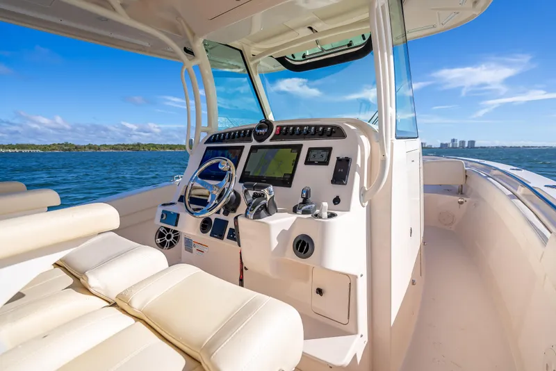 Slide: The Image of 2023 Grady-White 336 Canyon boat interior with modern dashboard and ocean view. - 32