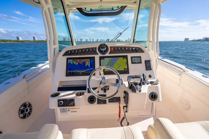 Slide: The Image of 2023 Grady-White 336 Canyon boat dashboard with navigation screens on open water. - 33