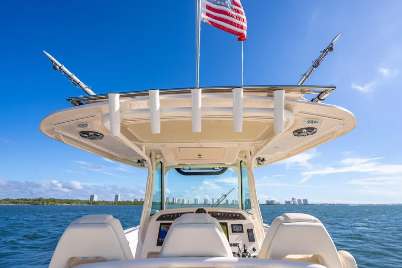 Slide: The Image of 2023 Grady-White 336 Canyon boat on open water, clear sky, American flag flying. - 35