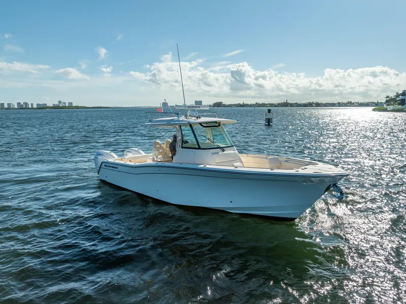 Slide: The Image of 2023 Grady-White 336 Canyon boat on sunny water, city skyline in background. - 4