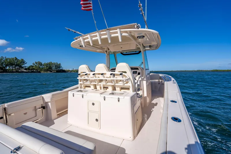 Slide: The Image of 2023 Grady-White 336 Canyon boat on open water, clear sky, and American flag. - 45