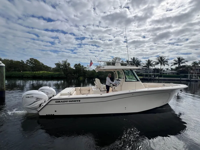 Slide: The Image of 2023 Grady-White 336 Canyon boat on calm water under cloudy sky. - 60