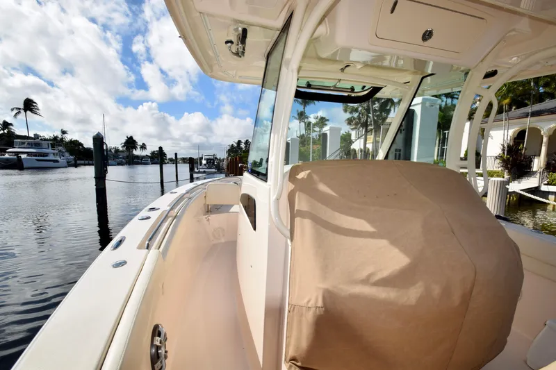 Slide: The Image of 2023 Grady-White 336 Canyon boat docked by waterfront homes under a blue sky. - 69