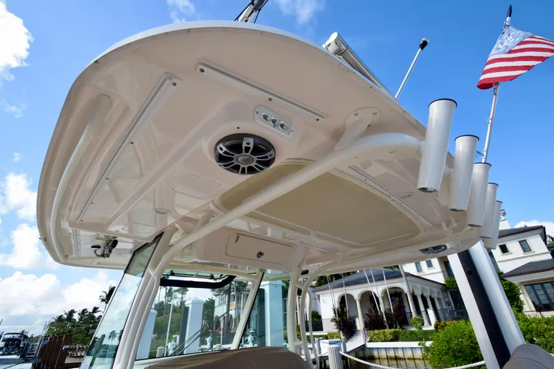 Slide: The Image of 2023 Grady-White 336 Canyon boat with T-top and rod holders, docked under blue sky. - 72