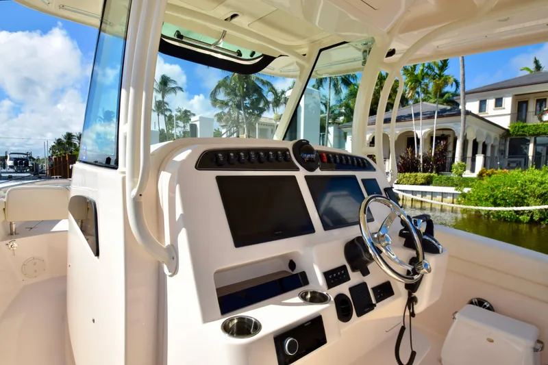 Slide: The Image of 2023 Grady-White 336 Canyon boat cockpit with modern controls and steering wheel. - 77