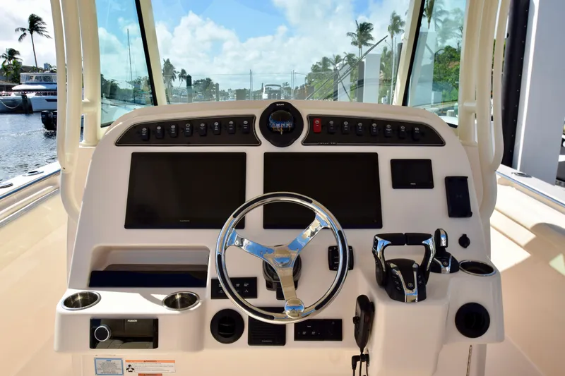 Slide: The Image of 2023 Grady-White 336 Canyon boat dashboard with steering wheel and navigation controls. - 78