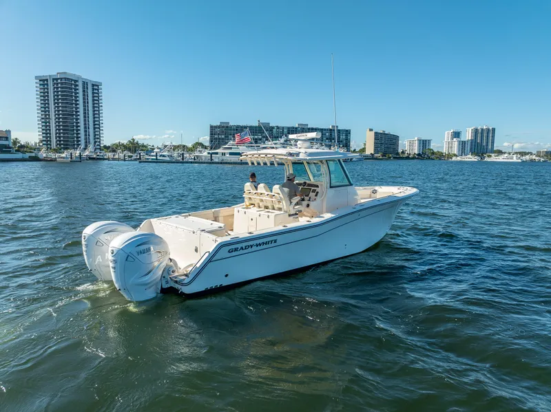 Slide: The Image of 2023 Grady-White 336 Canyon boat cruising in a city harbor. - 8