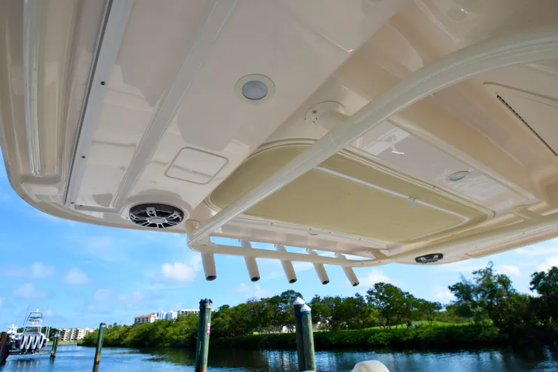 Slide: The Image of 2023 Grady-White 336 Canyon boat canopy with rod holders and speakers, docked by water. - 82