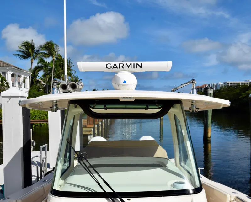 Slide: The Image of 2023 Grady-White 336 Canyon boat with Garmin radar, docked by palm trees. - 87