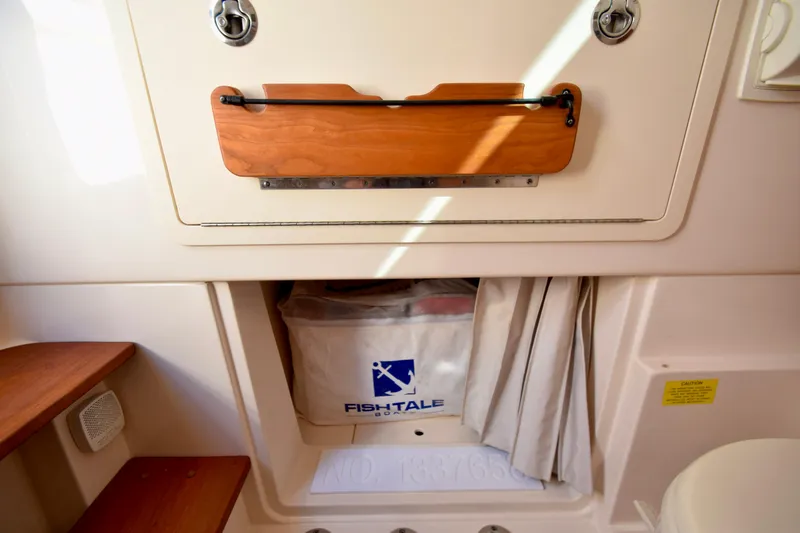 Slide: The Image of 2023 Grady-White 336 Canyon interior storage compartment with wooden accents and Fish-Tale bag. - 93