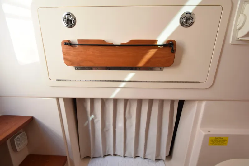 Slide: The Image of 2023 Grady-White 336 Canyon cabin interior with wooden accents and storage compartment. - 94