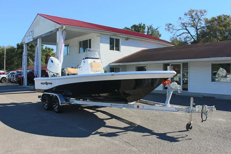 Slide: The Image of 2025 NauticStar 214 Shallow Bay boat on trailer, parked outside a building. - 5