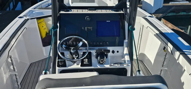 Slide: The Image of 2023 Yamaha Boats 255 FSH Sport E dashboard with steering wheel and controls. - 13