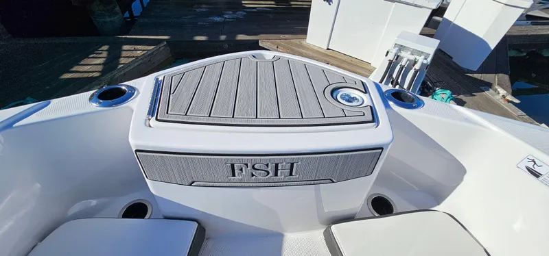 Slide: The Image of 2023 Yamaha Boats 255 FSH Sport E bow seating area with cup holders and storage. - 19