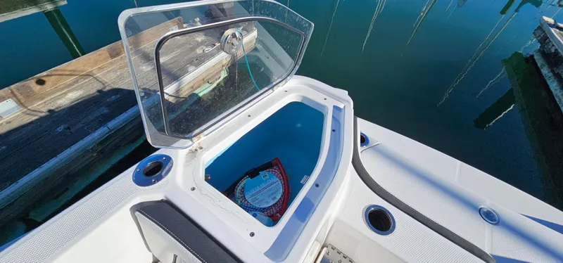 Slide: The Image of 2023 Yamaha Boats 255 FSH Sport E open storage compartment by the dock. - 21