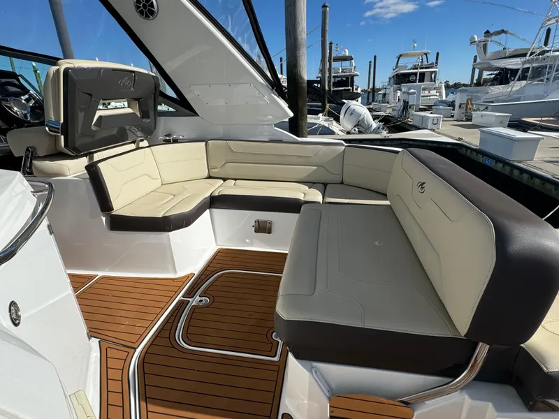 Slide: The Image of 2018 Monterey 335 SY boat with spacious seating and teak flooring at a marina. - 11