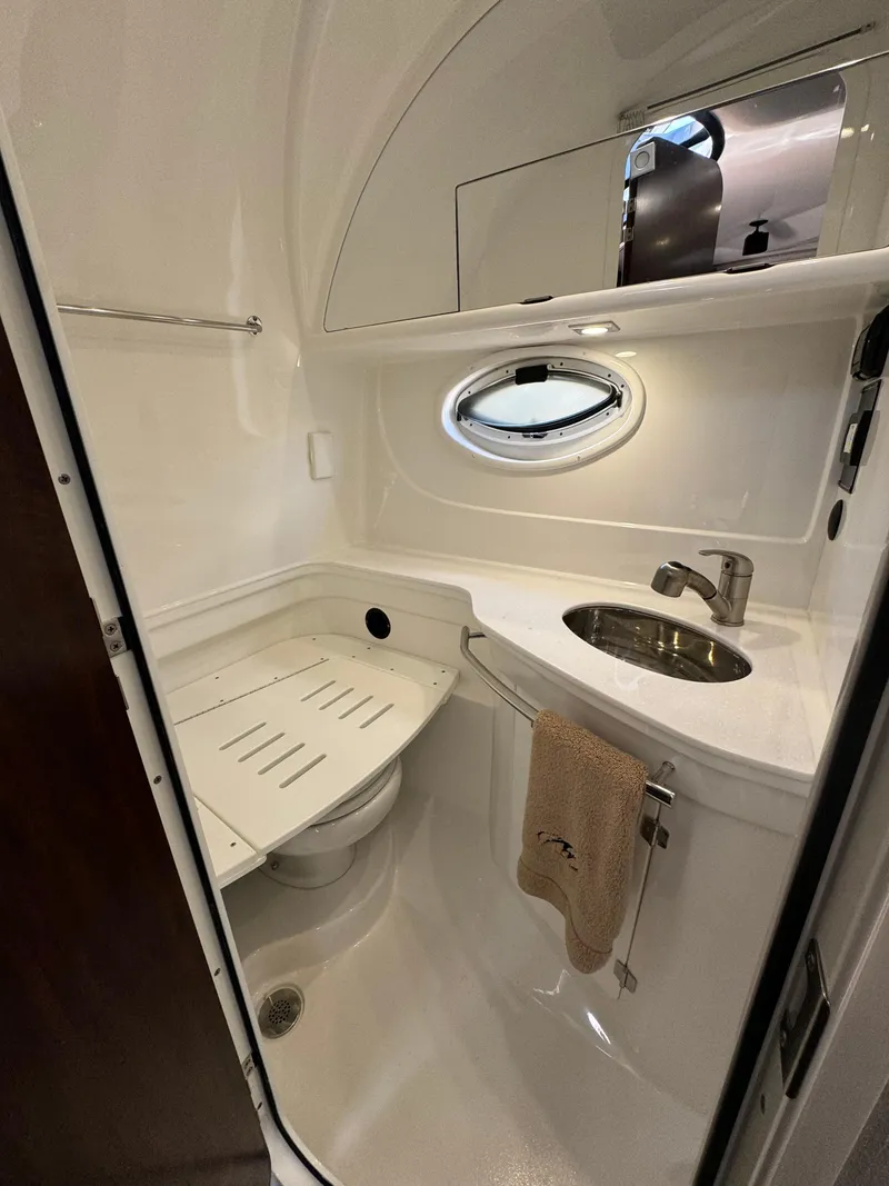 Slide: The Image of 2018 Monterey 335 SY boat bathroom with sink, mirror, and porthole window. - 24