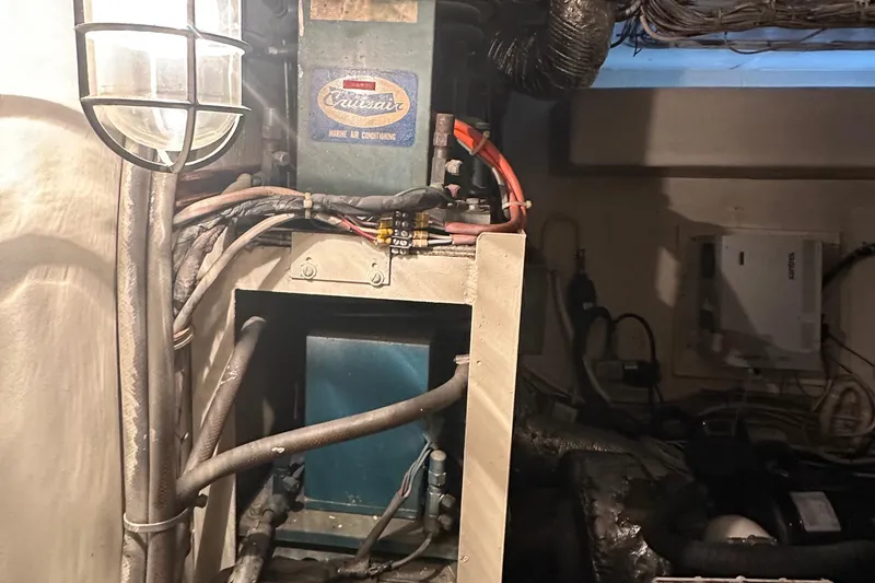 Slide: The Image of Engine room of 1974 Hatteras 58 Yachtfish, showcasing wiring and machinery components. - 12