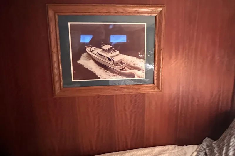 Slide: The Image of Framed photo of a 1974 Hatteras 58 Yachtfish on a wooden wall. - 15