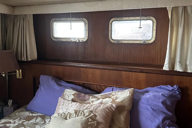 Slide: The Image of Cozy cabin interior of 1974 Hatteras 58 Yachtfish with porthole windows and plush bedding. - 19