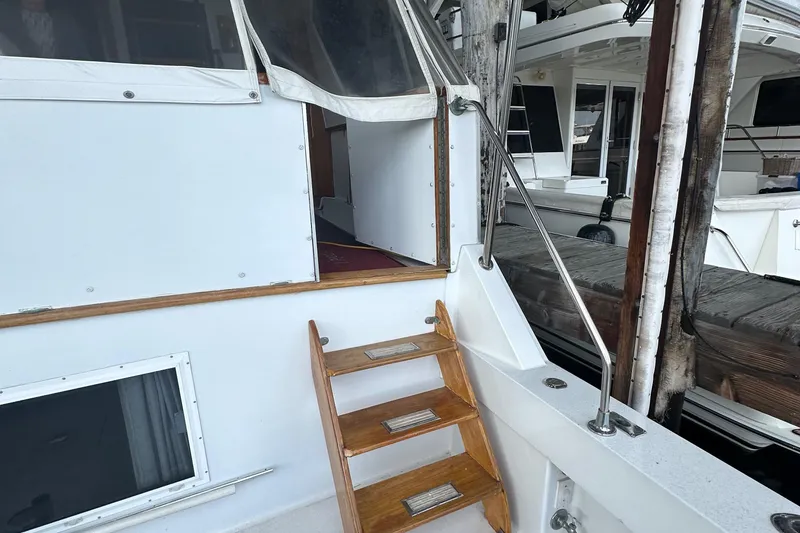 Slide: The Image of 1974 Hatteras 58 Yachtfish with wooden steps and open cabin door at dock. - 2