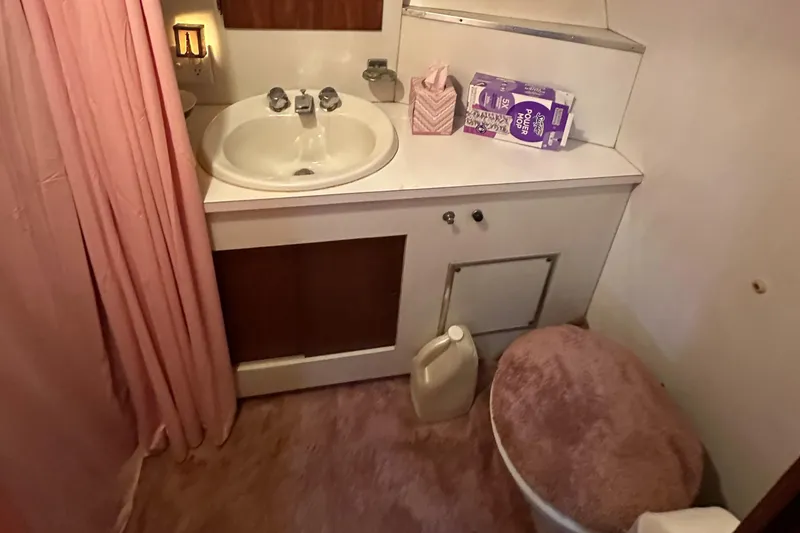 Slide: The Image of 1974 Hatteras 58 Yachtfish bathroom with sink, toilet, and pink decor. - 26