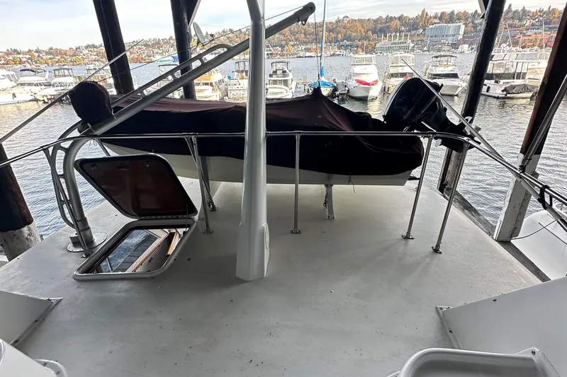 Slide: The Image of 1974 Hatteras 58 Yachtfish deck with marina view, open hatch, and covered equipment. - 30