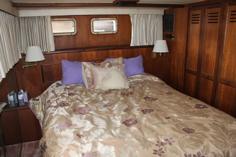 Slide: The Image of Luxurious bedroom interior of 1974 Hatteras 58 Yachtfish with floral bedding and wood paneling. - 31