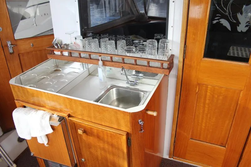 Slide: The Image of 1974 Hatteras 58 Yachtfish interior with wooden cabinetry and sink area. - 35