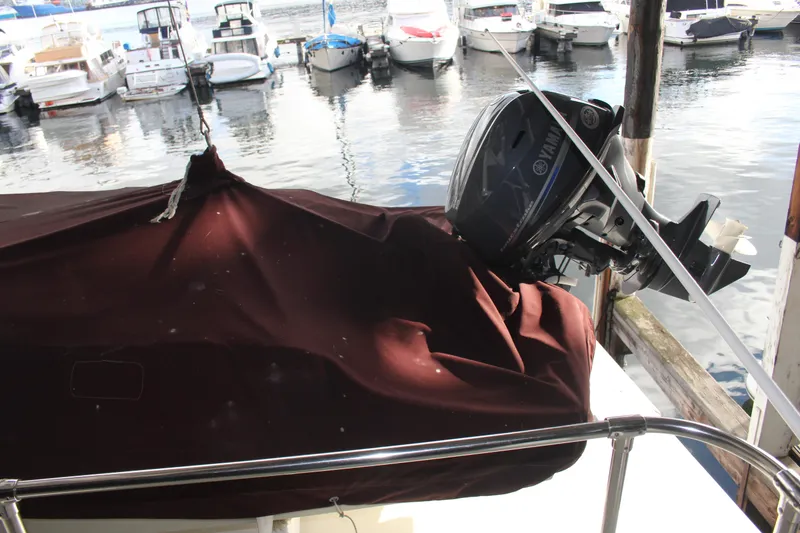 Slide: The Image of 1974 Hatteras 58 Yachtfish with covered outboard motor at marina. - 39