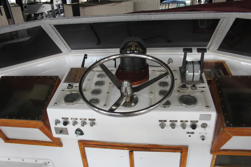 Slide: The Image of 1974 Hatteras 58 Yachtfish helm with steering wheel and control panel. - 40