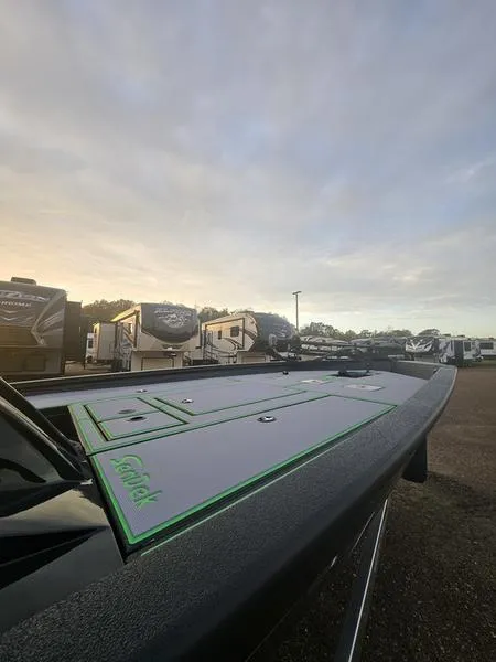 Slide: The Image of 2025 Xpress H20C Crappie boat at sunrise, parked near RVs. - 11