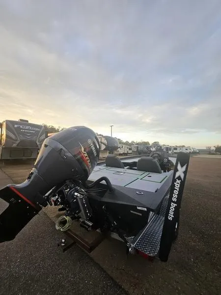 Slide: The Image of 2025 Xpress H20C Crappie boat with powerful outboard motor in a parking lot. - 5